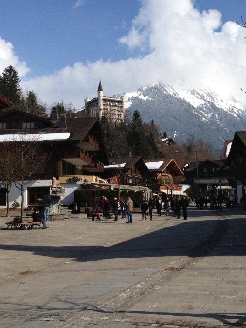 Gstaad Dorfplatz mit Palace Hotel und verschneiten Bergen